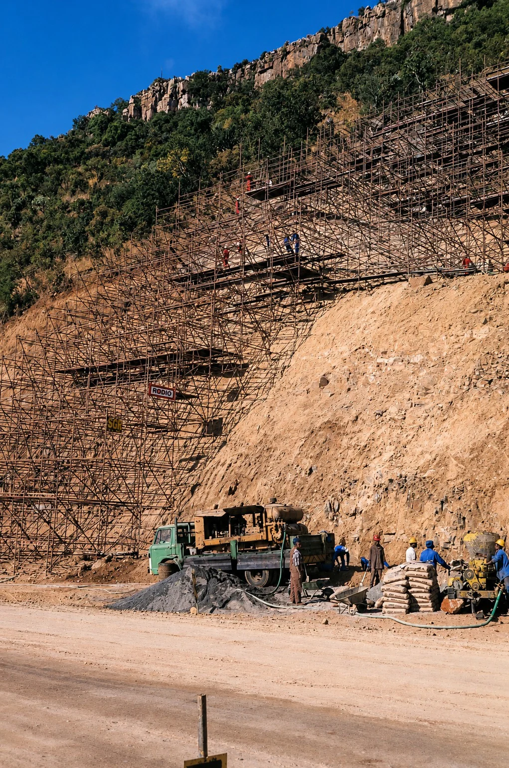 Curtis gunite crew stabilising a mountain cutting at Waterval Boven in 1982 — scaffolding up the rock face, the gunite rig below